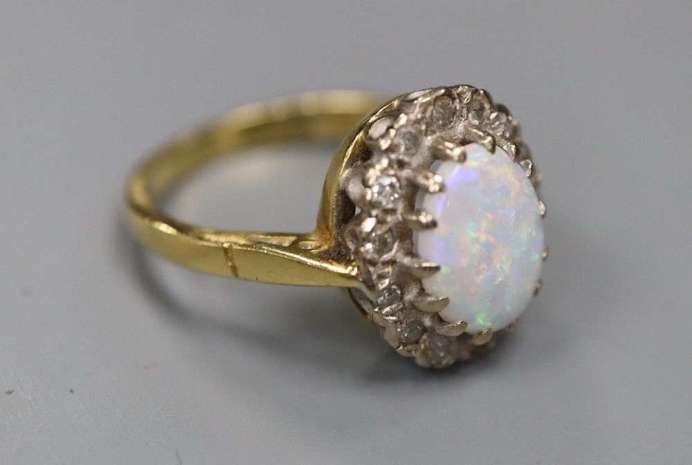 A modern 18ct gold, white opal and diamond set oval cluster ring, size J, gross 4.4 grams.